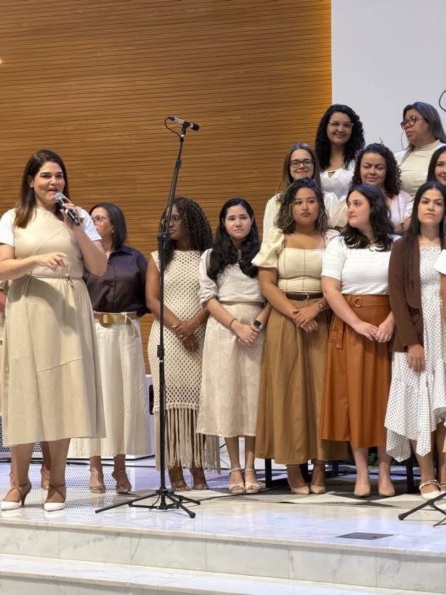 Grupo de vozes femininas do coral reunidas no palco