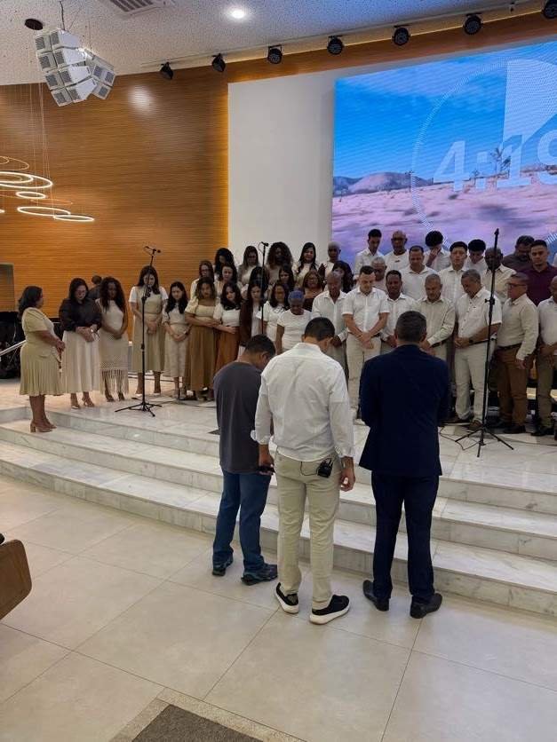 Coral reunido em momento de oração antes da apresentação
