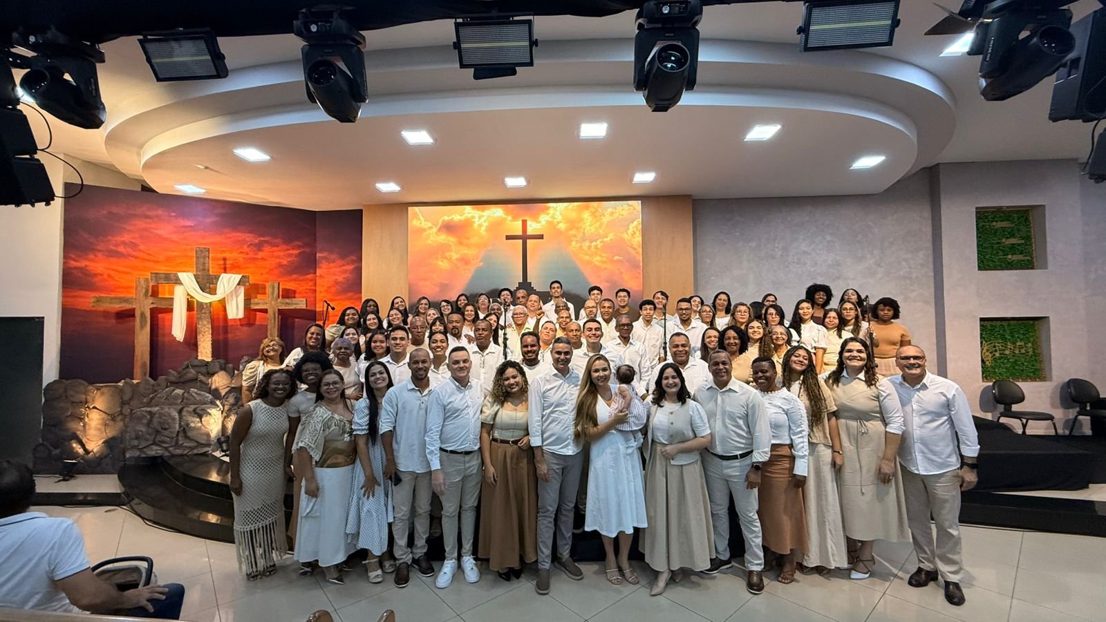 Porto Coral reunido no palco, coral completo diante de cenário com cruzes